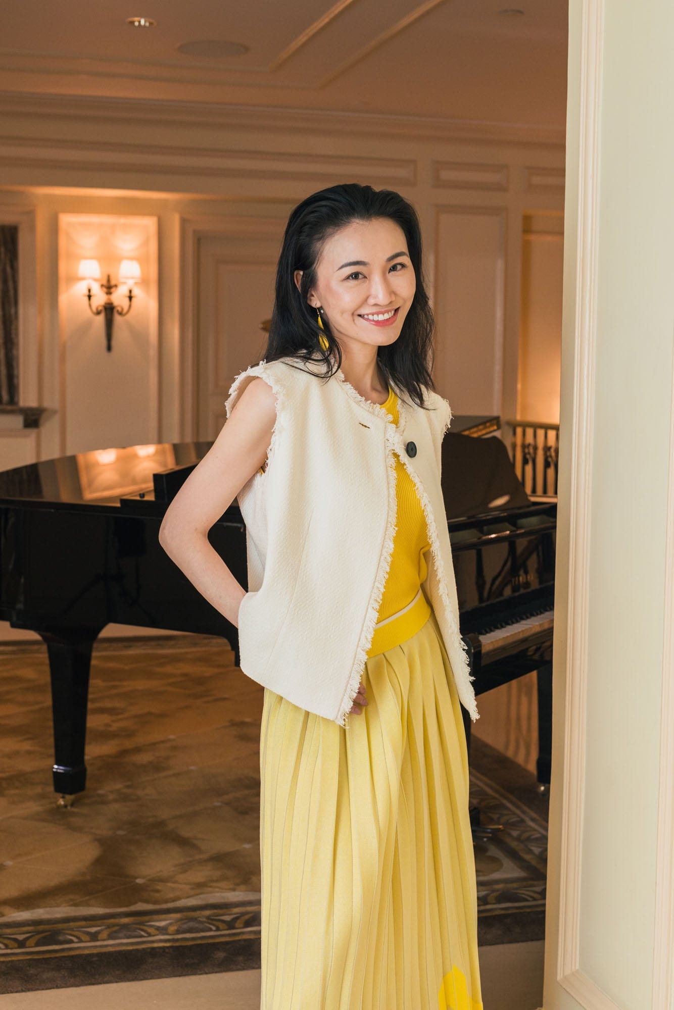 Guest in a yellow Anteprima look beside a piano