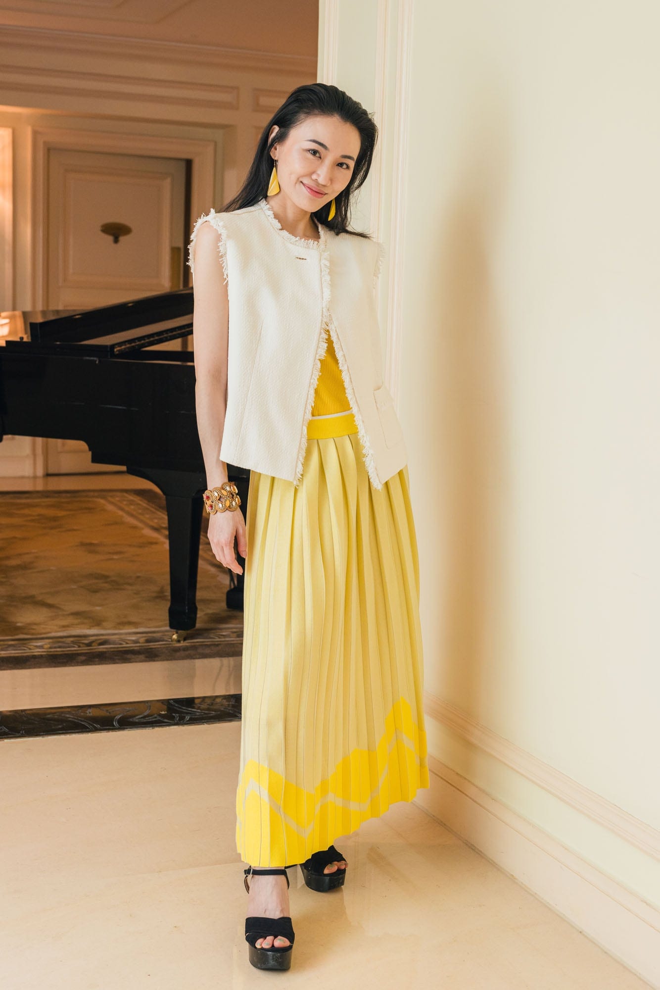 Guest in a yellow Anteprima look beside the piano