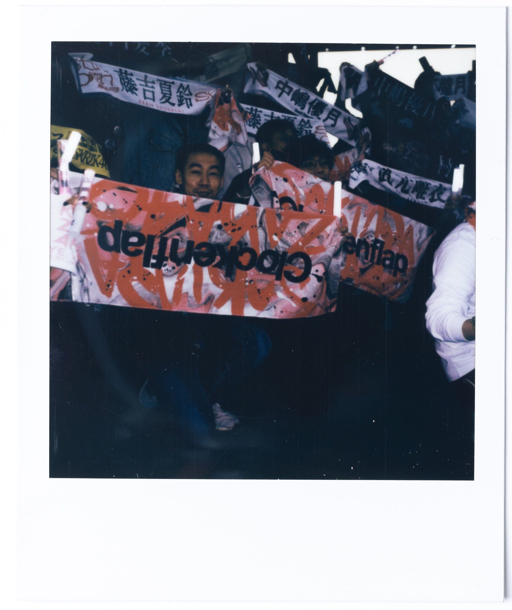 Clockenflap crowd holding a deja vu boys banner on Polaroid film