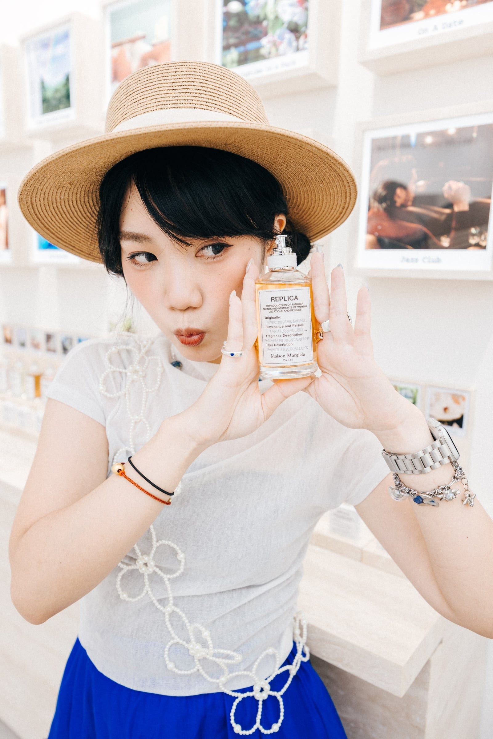 Guest holding Maison Margiela fragrance in a sun hat