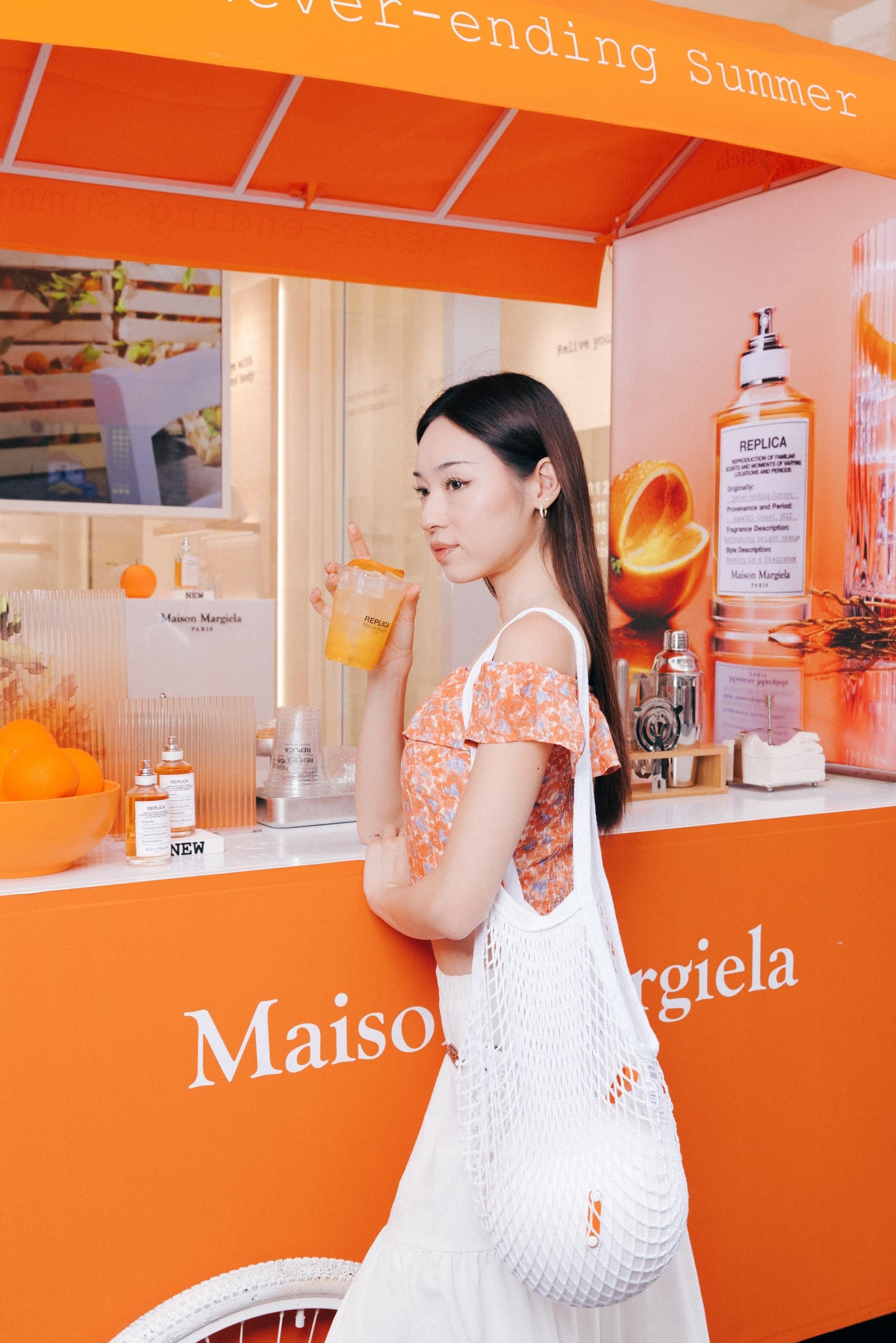 Guest at the orange Never-Ending Summer Maison Margiela bar