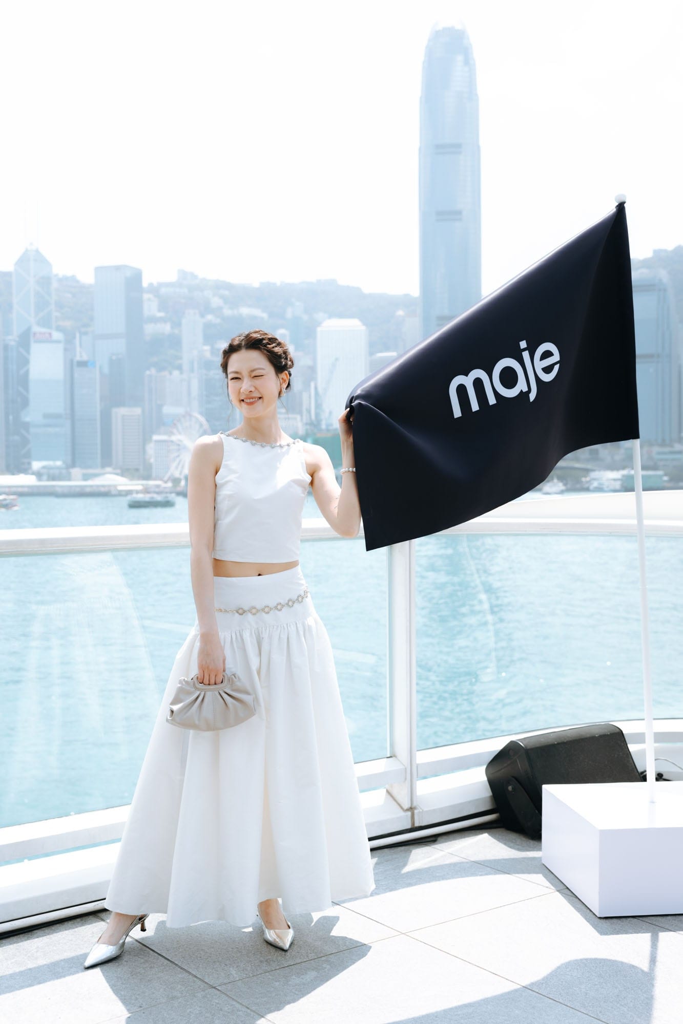 Guest holding a Maje flag on the Hong Kong waterfront