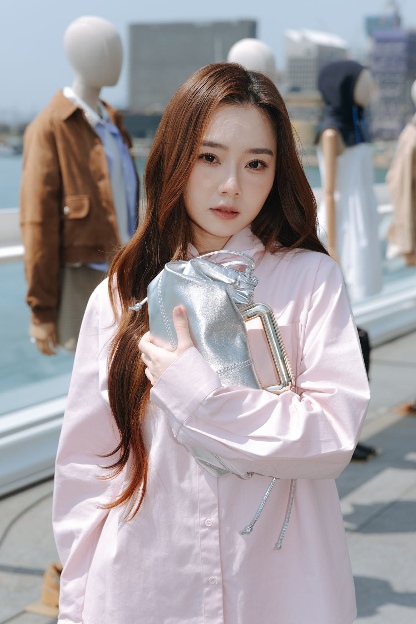 Guest holding a silver Maje bag at the SS26 presentation