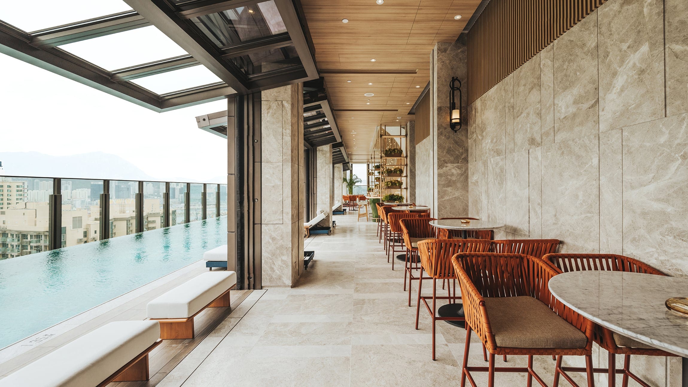 The Vantage interior with poolside seating, marble walls and city views