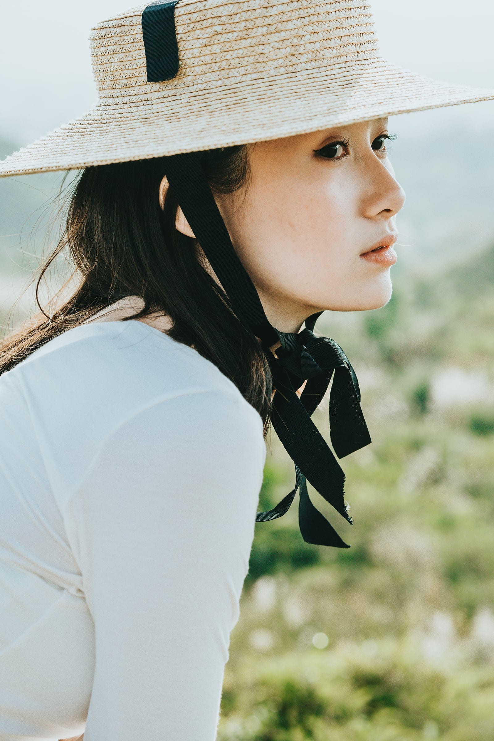 Close portrait framed by a wide woven hat