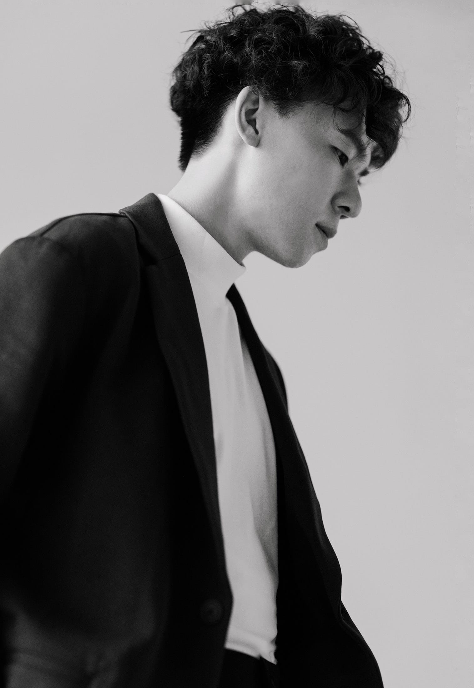 Black-and-white portrait of a person in a dark suit