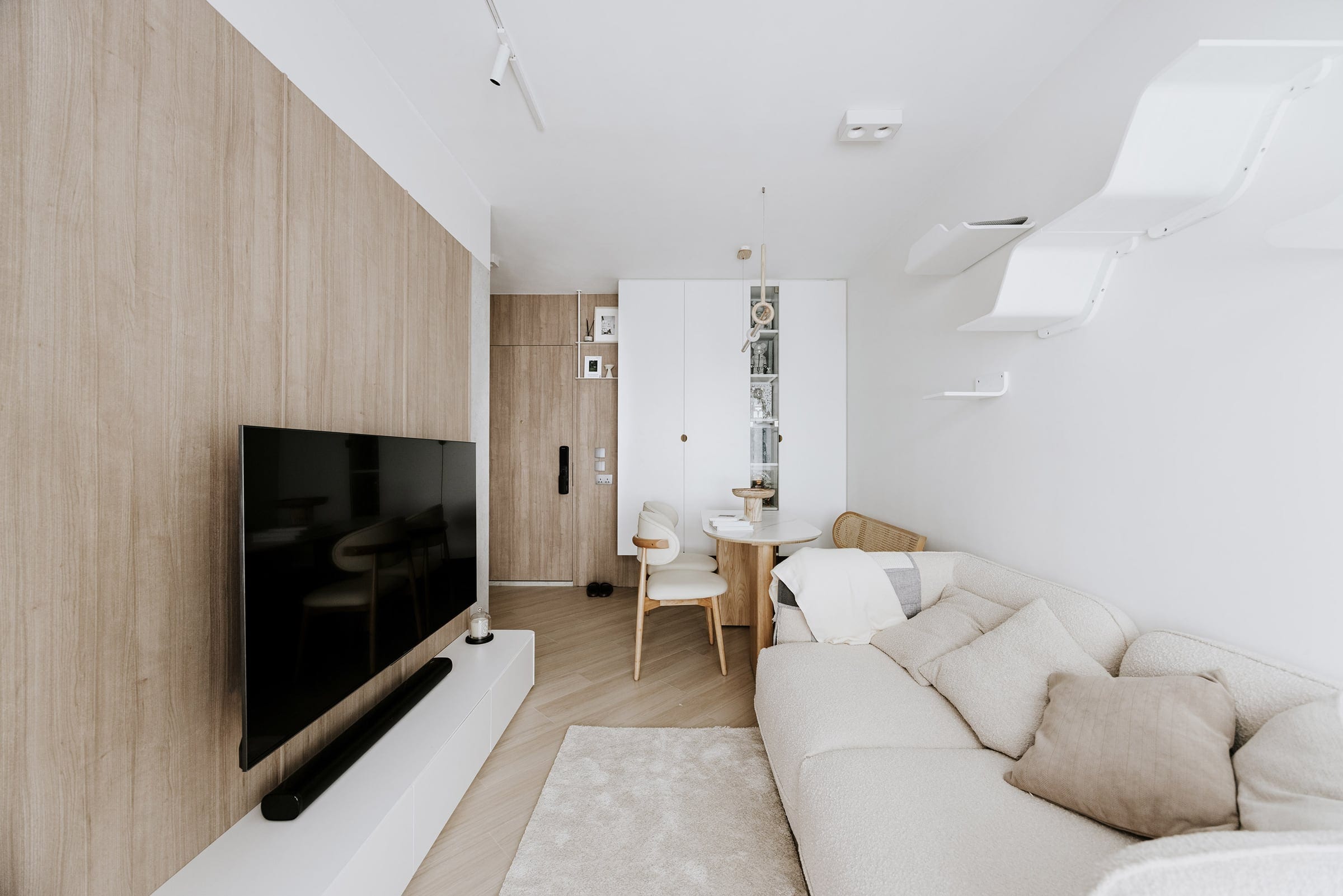 Kai Chuen Court living room with curved cat wall and pale timber joinery