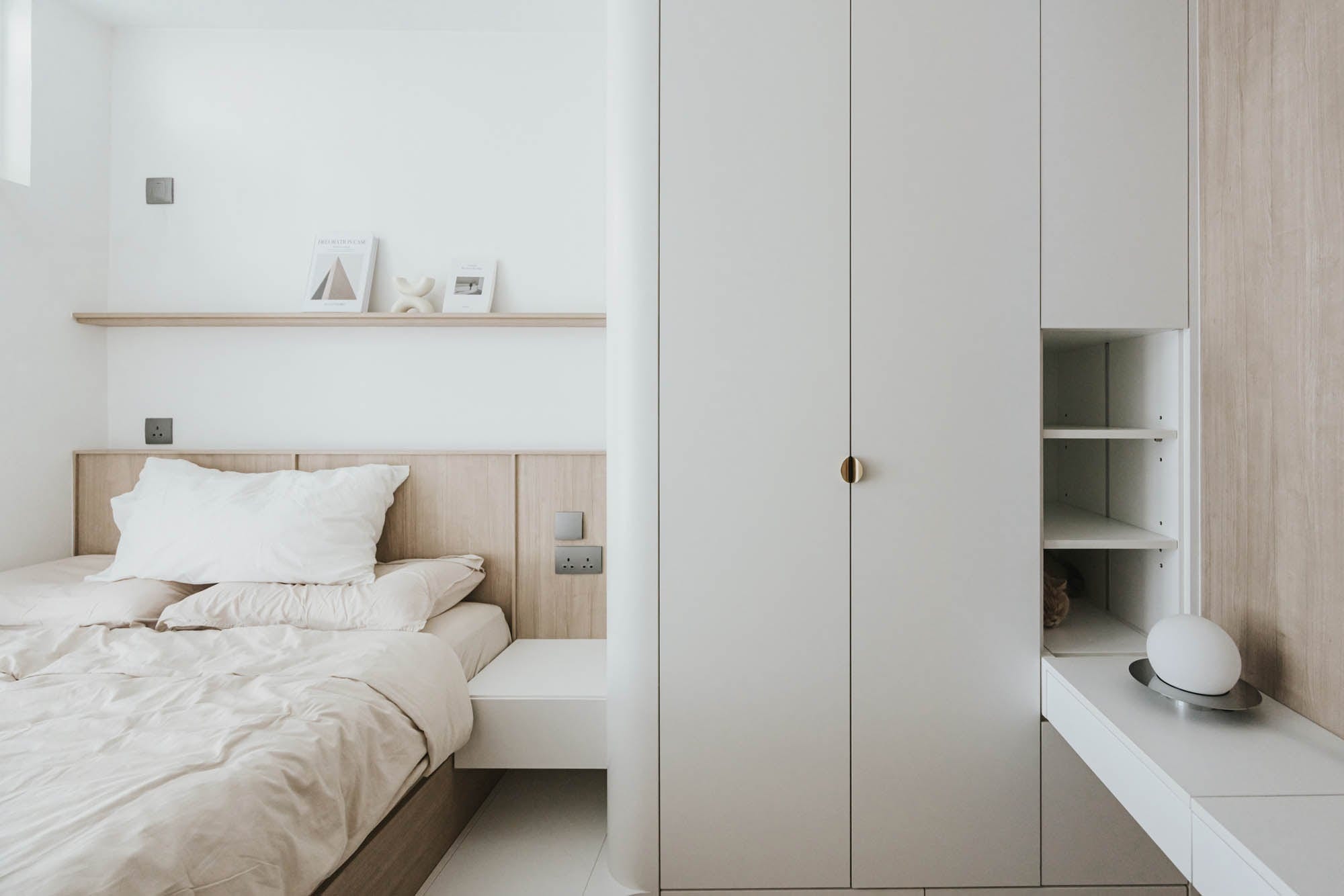 Kai Chuen Court bedroom with built-in storage and pale timber detailing