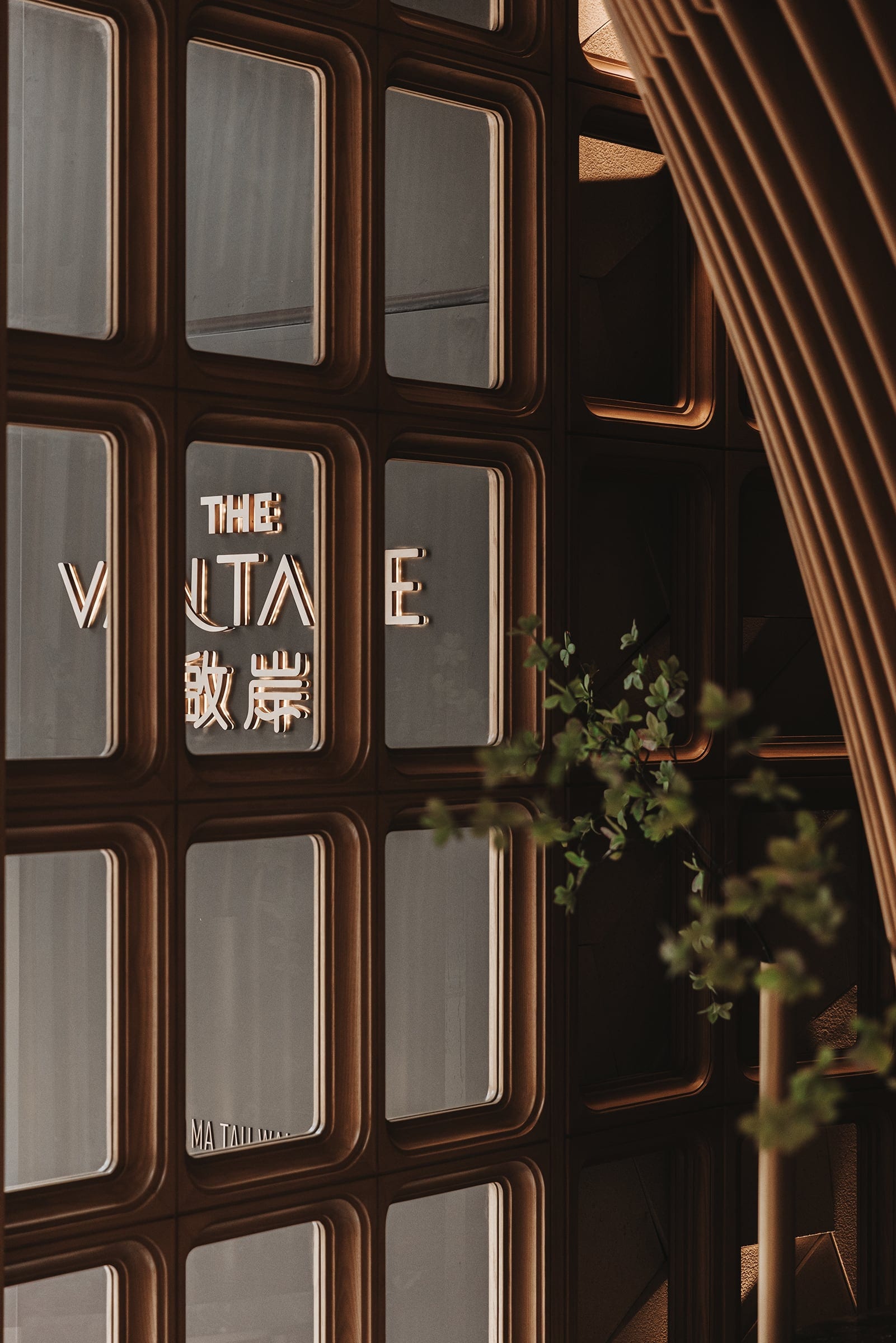 The Vantage sign set within a dark timber wall